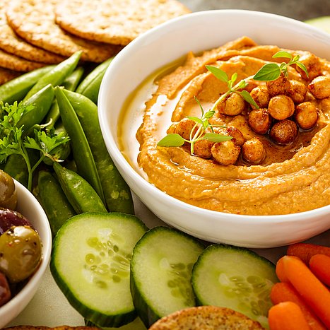 Weiße Schlüssel mit Hummus, außen rum frisches Gemüse.