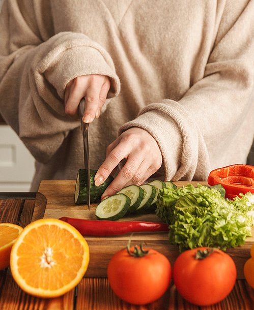 Gesundes Essen ist bei einer Erkältung eine echte Wohltat. Frau bereitet gesundes Essen zu.